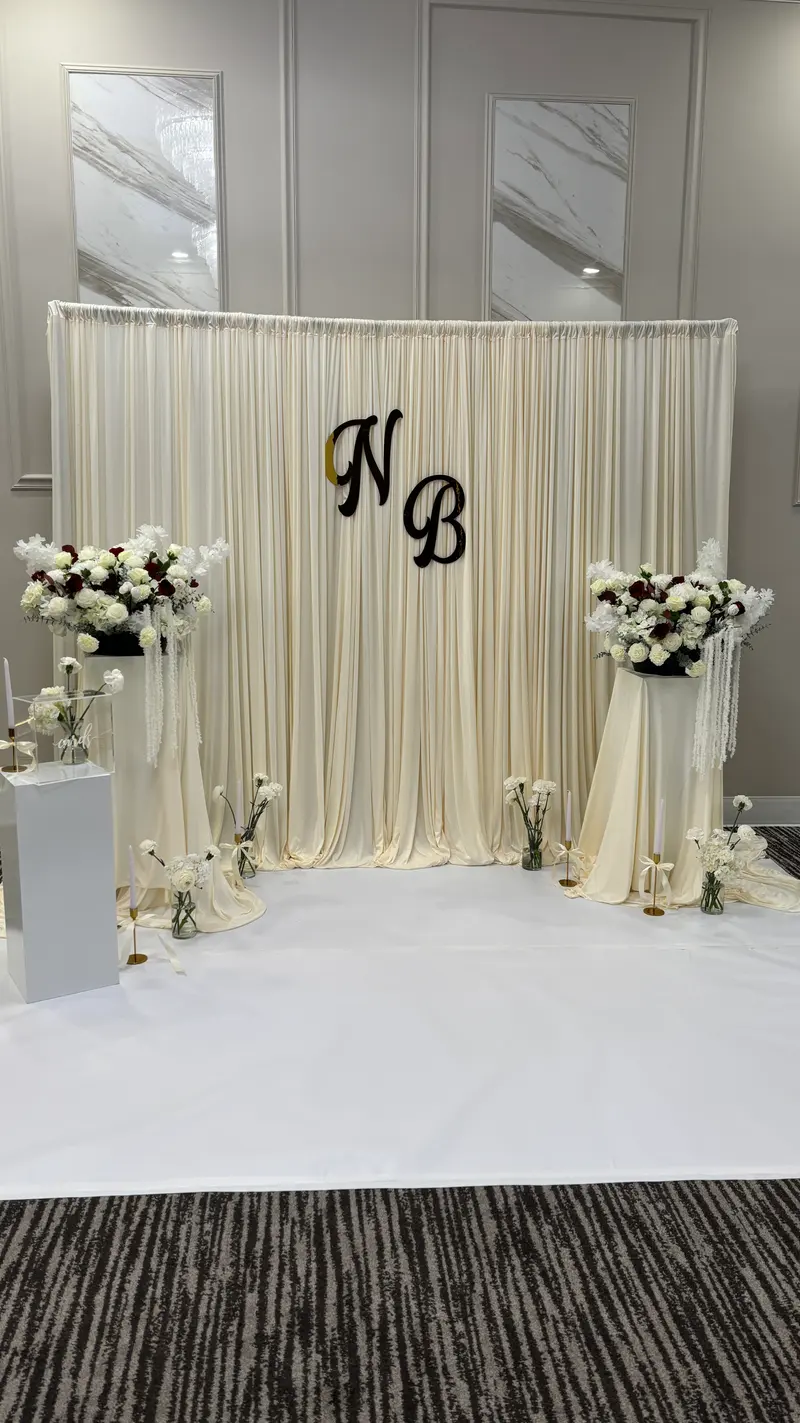 Wedding backdrop with white and burgundy floral arrangements by LÓLA Flowers